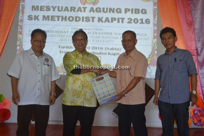 Methodist Headmaster Demang Sawing (second right) presents a memento to Nanta. PTA chairman Dominic Chunggat is at left while at right is Sarawak Dayak Graduates Association Kapit chairman Layang Bugek. 