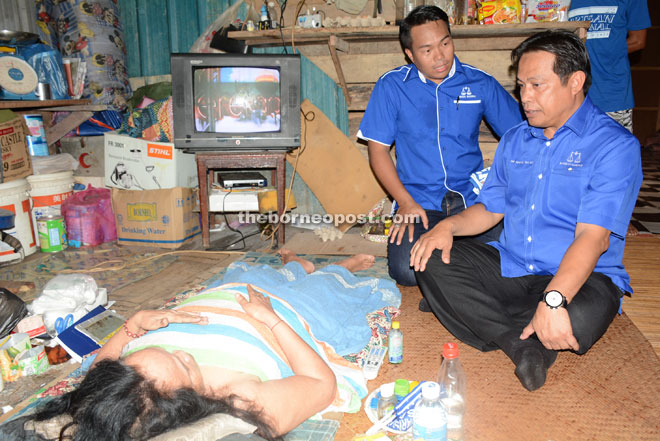 Dr Abdul Rahman (right) and Sufian comfort a bedridden Julia, 54, at RH Siad during the campaign trail. 