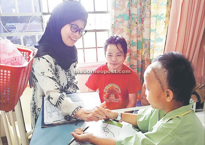 Fatimah plays with the injured boy during the hospital visit.