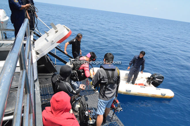 Media personnel and divers getting off from an MMEA vessel to board a smaller raft, which transported them to Beting Patinggi Ali.