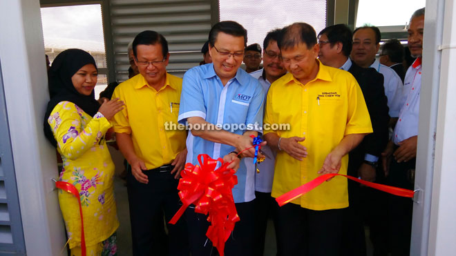 Liow cutting the ribbon to declare open the Miri Airport’s new covered walkway and apron, witnessed by Lee (second left) and Ting (right).