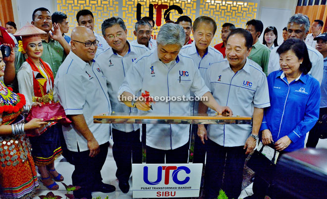Ahmad Zahid signing the UTC plaque while Wong (second right), Janet (far right), Tiong (third right) and others look on.  — Photo by Othman Ishak 