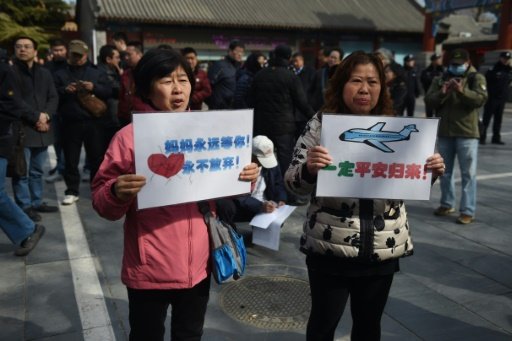 Relatives of passengers missing on Malaysia Airlines MH370 hold placards outside the Lama Temple in Beijing in March. - AFP Photo