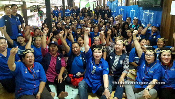 Doris (centre) and other PRS women exco pump the air and shout the BN slogan. 