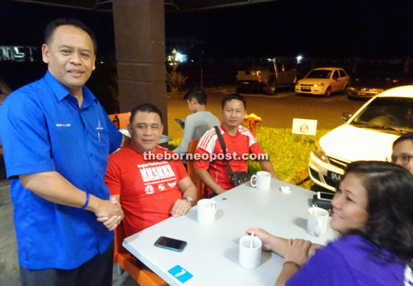 Henry (left) greeting the people during a gathering with NGOs and youths at 1Singai Tondong commercial centre on Friday night. — Photo by Anasathia Jenis