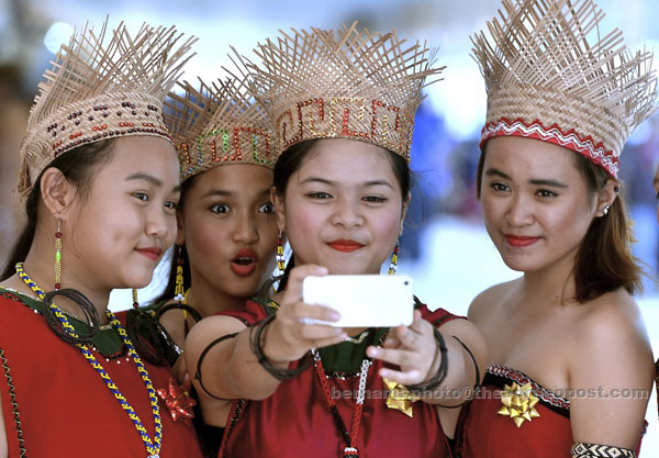 ATTRACTIVE: Four Penan girls from Rumah Mareng, all dressed in full traditional costumes, gather up for a wefie before the arrival of Prime Minister Datuk Seri Najib Tun Razak to their longhouse. — Bernama photo.