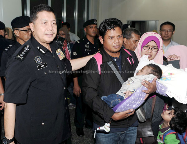 Wan Ahmad welcoming Norashikin and Tarmizi, who is carrying Fakrullah, at Senai International Airport. — Bernama photo