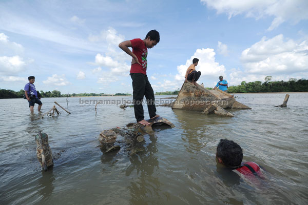 Villagers of Kampung Tanjung in Pekan, Pahang taking a closer look at a British merchant vessel that had sunk under mysterious circumstances 100 years ago. — Bernama photo
