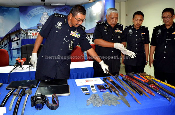 Ramli (left) with his men show the seized weapons during a press conference. — Bernama photo