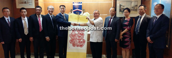 Wang (fifth left) presenting a souvenir to Chan. 