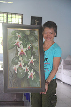 Yeo shows one of her paintings for sale at the SSD centre.