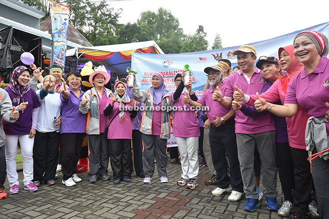 LOVE IS IN THE AIR: Some 7,000 people participating in the ‘Sarawak Volunteers, Walk of Love’ held in Kuching yesterday. Picture shows the Chief Minister’s wife, Datin Patinggi Datuk Jamilah Anu (left) and Minister of Welfare, Women and Community Wellbeing, Datuk Fatimah Abdullah flagging off the participants.
