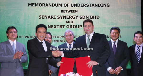 Senari Synergy group managing director Jefri Ahmad Tambi (front, left) is seen exchanging documents with NextBT CEO Michael Petras (front, right), witnessed by Awang Tengah (centre), Misnu Taha (back row, second left), Dr Hazland Abang Hipni (left) and other VIPs. — Photo by Kong Jun Liung