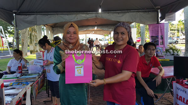 Salina (left) presenting prizes to one of the lucky draw winners.