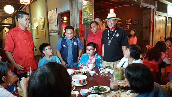 Miro (standing second left) and Nazri (standing right) chat with diners during their walkabout at the Siniawan night market.