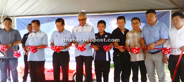 Lee (third from left), Junaidi (fourth from left) and Hu (fifth from left) at the ribbon-cutting ceremony symbolising the launching and opening of the Miri community policing office in Lutong Baru.
