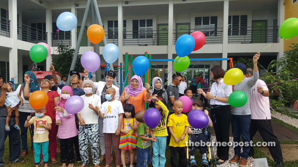 Rohani (centre) and others about to release balloons to officiate at the event.