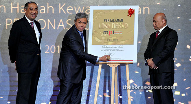 Ahmad Zahid signs the front cover in a symbolic launch of the MPI book.