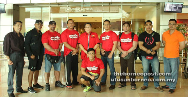 SELAMAT KEMBALI: Andy (empat kanan) dan Presiden SBBA Datuk Wee Hong Seng (lima kiri) bersama atlet bina badan Zon Kuching sebaik tiba di Lapangan Terbang Antarabangsa Kuching, semalam.