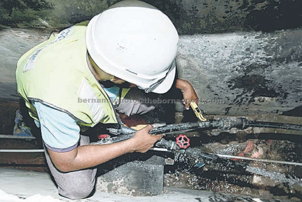 Syabas officer locking the waterway during an operation. — Bernama photo