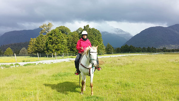 Aliya tries out horse riding during a free day.