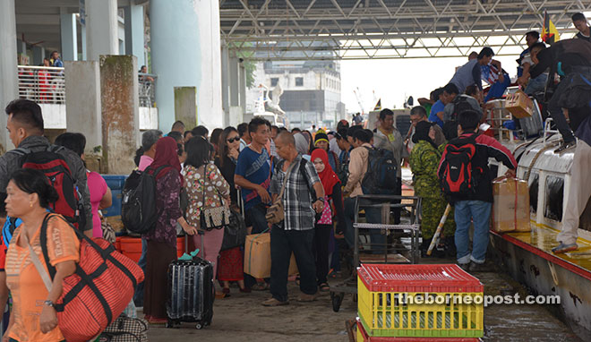 TIME TO CELEBRATE AGAIN: The ‘balik kampung’ crowd at Sibu Express Boat Terminal yesterday. Passenger volume at the terminal soared to 4,392 on Friday. It was only 2,747 on Thursday. — Photo by Peter Boon