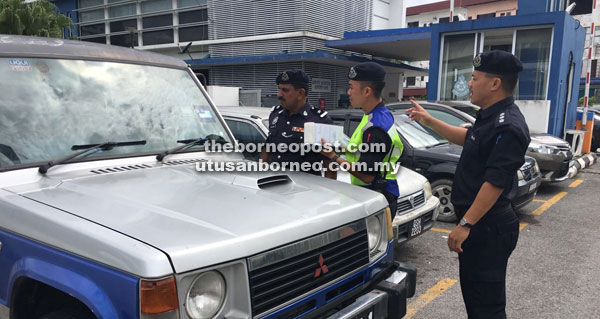 AMBIL TINDAKAN: Polis mengeluarkan saman terhadap kenderaan pacuan empat roda yang ditinggalkan di garisan kuning berhampiran pondok polis di Balai Polis Sentral Sibu, semalam.