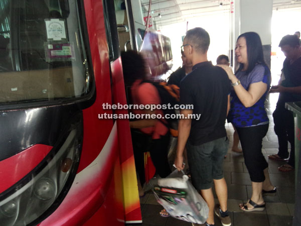 SELAMAT JALAN: Penumpang mula menaiki bas untuk bertolak ke kampung halaman ketika tinjauan Utusan Borneo di Kuching Sentral, semalam. (Gambar kiri)