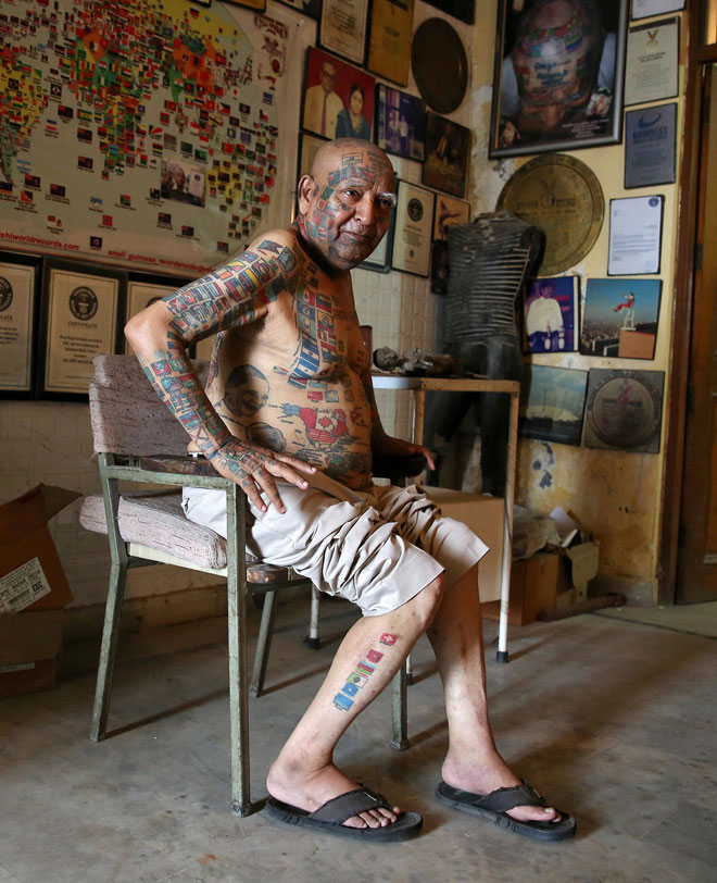 Rishi multiple world record holder including most flags tattooed on his body, poses for a photograph outside his apartment in New Delhi, India. — Reuters photo