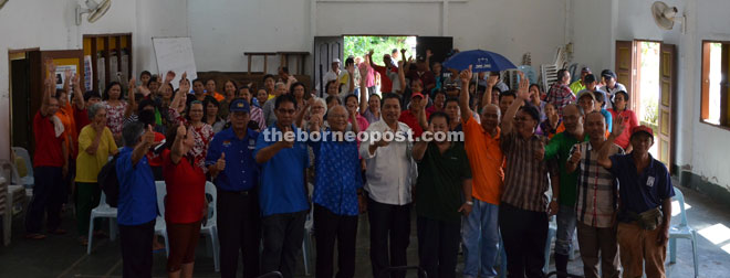 Idris (centre), together with Minos (fifth left), Jiku (fifth right), Lawrence (sixth right) and others react during a gathering at Kampung Entingan.  