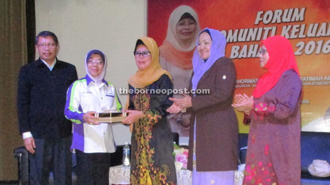 Fatimah (third right) receives a souvenir from Rohani after the launching ceremony. 