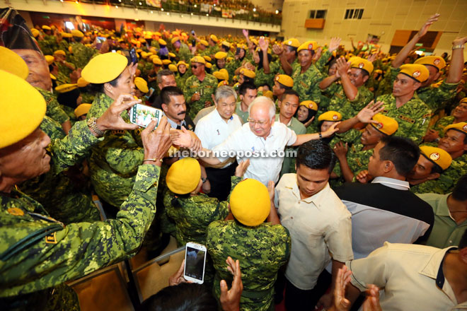 Najib (centre), with Ahmad Zahid behind him, enters the hall to the applause of Rela personnel. 