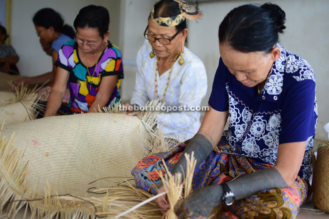 The weavers putting the finishing touches at Sungai Asap Community Hall on Sunday. 