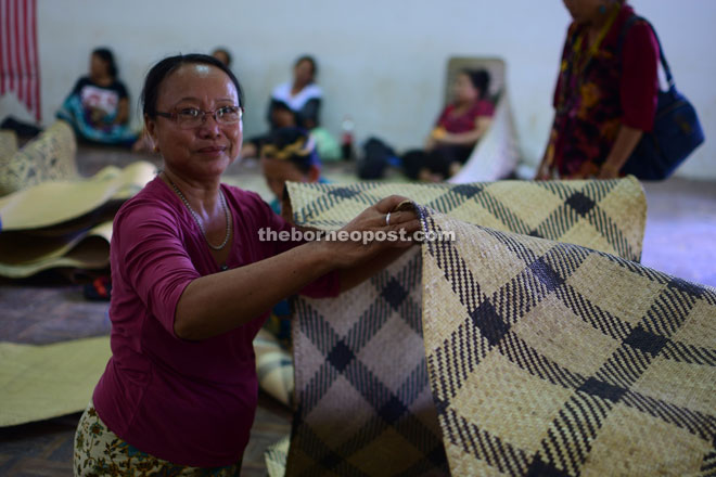 A weaver showing the mat. 