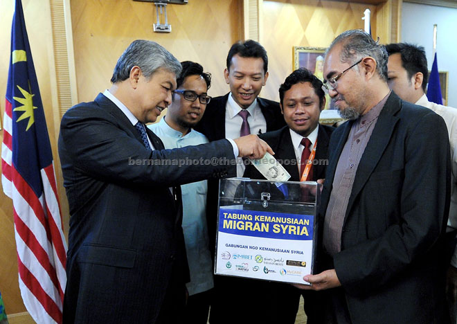 Ahmad Zahid (left) makes a personal donation to the Syria Immigrant Humanitarian Fund. — Bernama photo