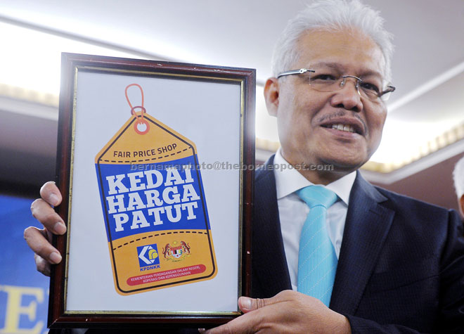 Hamzah shows ‘Kedai Harga Patut’ new logo during the KPDNKK monthly gathering and presentation of 2016 Certificates of Retirement. — Bernama photo