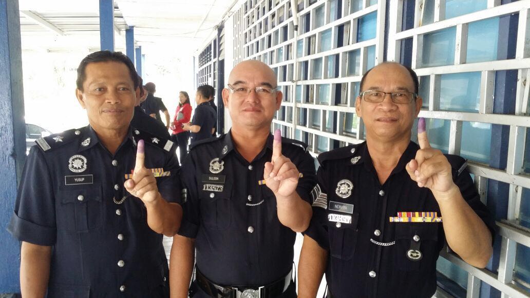 (From left) Sub-Inspector Yusop Naraue, Sergeant Suloon Gat and Sergeant Nervyn Kedit showing their index fingers after casting their ballots at Belaga police headquarters in Belaga district today. They are among a total of 24,604 early voters who cast their early votes at 79 polling centres statewide. Early voters consist of army, police and General Operations Force personnel and their spouses, as well as 106 postal voters. - Photo by Conny Banji