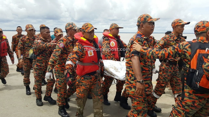 Bomba personnel transporting the body to SMK Sebuyau, here it will be flown to the Sarawak General Hospital.