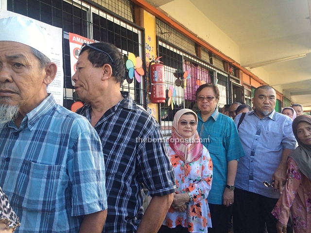 Abang Johari (fourth left) and his wife waiting in line to vote.