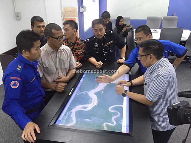 Azharuddin (right) and representatives of other agencies going over a map of the crash site.