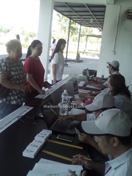 MP Lanang Alice Lau (standing centre) with mother Ha Fong Yieng (right) and grandma Long Leg Ting register at SMk Methodist to cat their votes for Bukit Assek constituency.