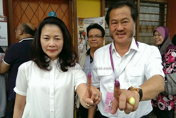 Direct BN candidate for N.74 Pujut Datuk Hii King Chiong and her wife Ting Hua Eng showing their fingers marked with indelible ink after cast their votes at SK Luak today.