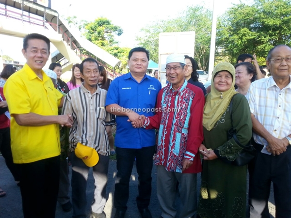 N.45 Repok candidate Dato Sri Huang Tiong Sii (third left) and N.46 Meradon Candidate Ding Kuong Hiing (left)greet voters in front of SK St. ANNE