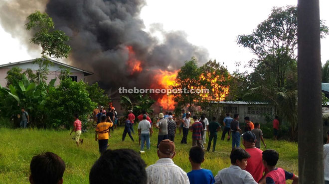 Neighbours gathering at the scene of the fire in Kampung Tupong Batu.