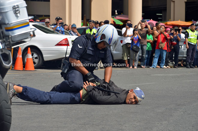 A policeman pinning down an ‘armed robbery suspect’ during the launch of ‘Ops Selamat’. 