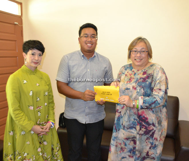 Azizul Annuar hands over a RM5, 000 cheque of his own personal donation to SCCS president Jocelyn Hee (right) as SCCS advisor Datuk Lorna Enan Muloon looks on. 