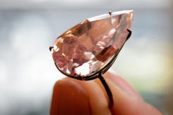 A model shows the "Unique Pink", a vivid pink diamond weighing 15.38 carats, during a press preview at Sotheby's auction house on May 9, 2016 in Geneva. Photo by AFP