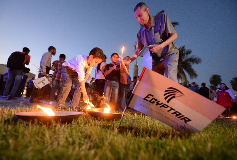 Egyptians light candles during a vigil for the victims of the EgyptAir flight that crashed in the Mediterranean, in Cairo on May 26, 2016. Photo by AFP
