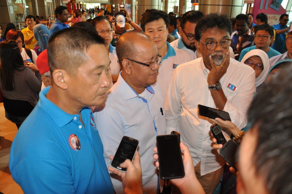 See (left), Zakaria (second left) and PKR central leadership council member Zakaria Abdul Hamid (right) attending to questions from reporters at Kuching International Airport.