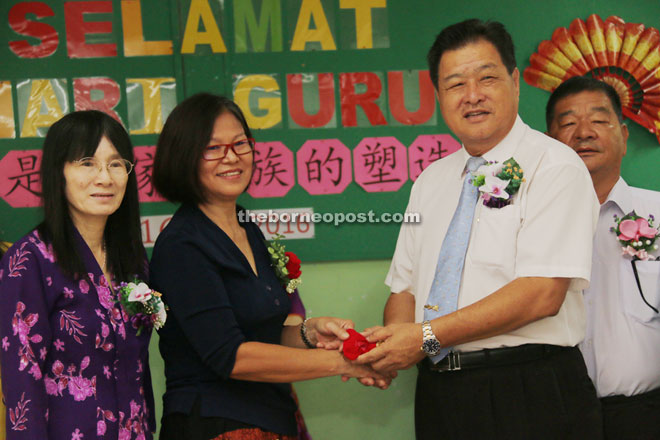 PTA chairman Siek King Kwong (second from right) presents a gift to a teacher. Wong is on the left.